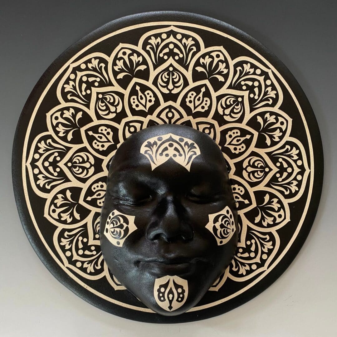 A black and white ceramic face on top of a plate.