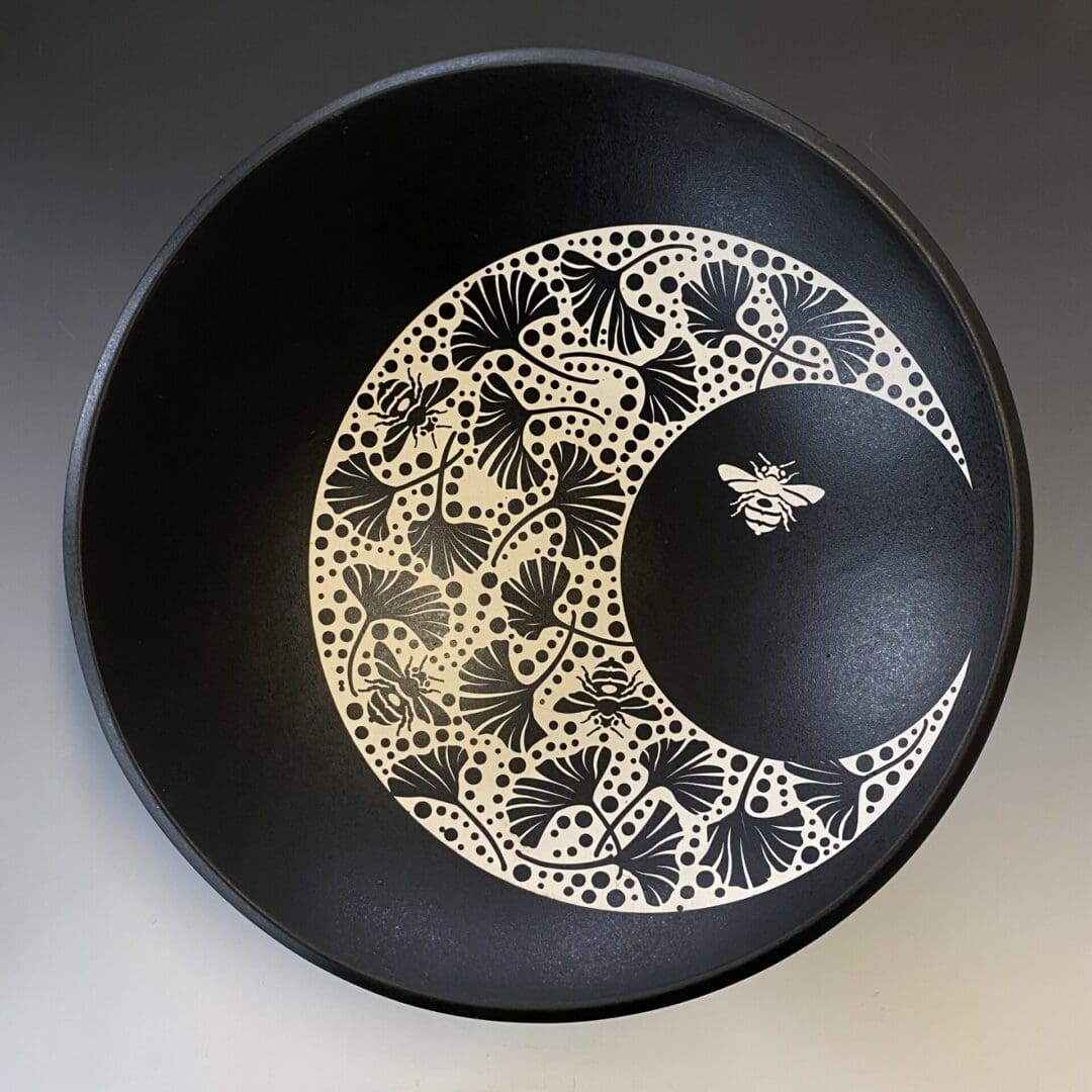 A black bowl with white lace design on it.