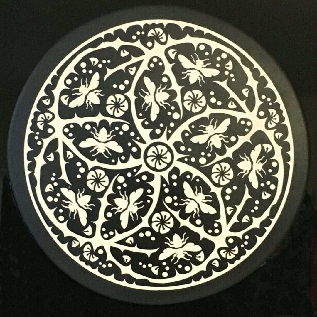 A black and white picture of a plate with a butterfly design.