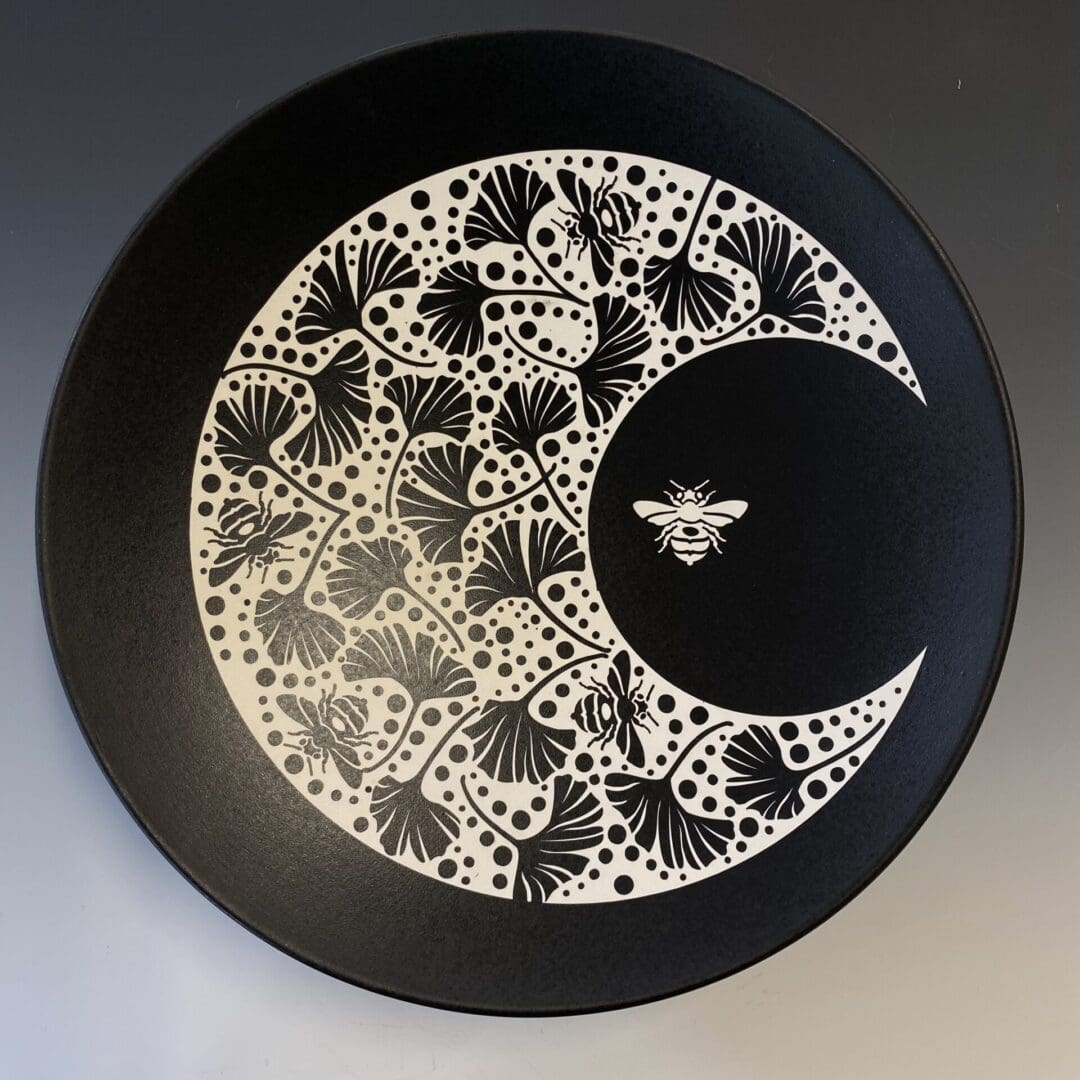 A black and white plate with a bee on it