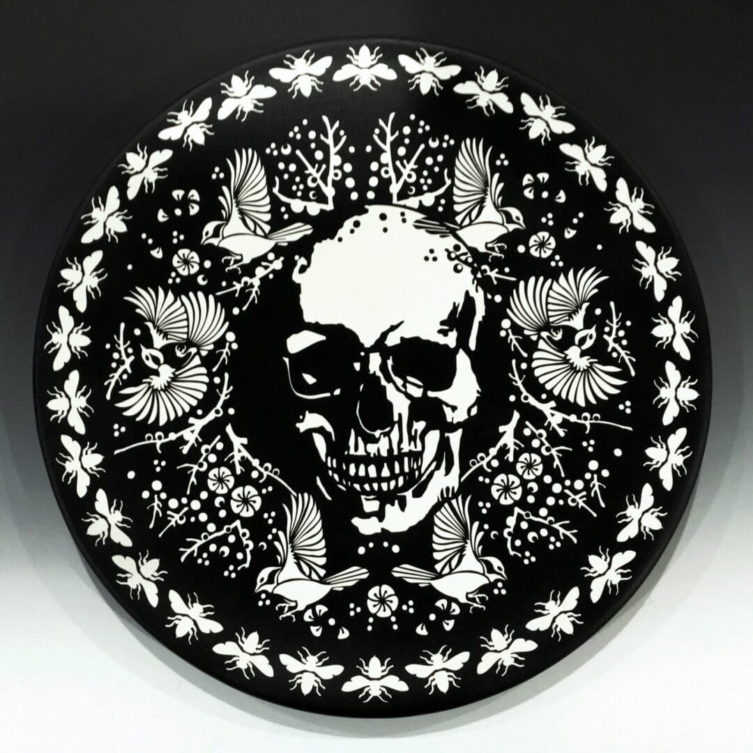 A black and white picture of a skull with flowers around it.