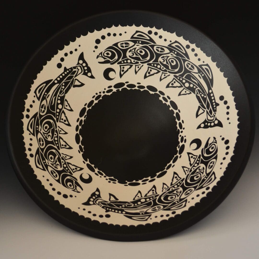 A black and white plate with fish on it