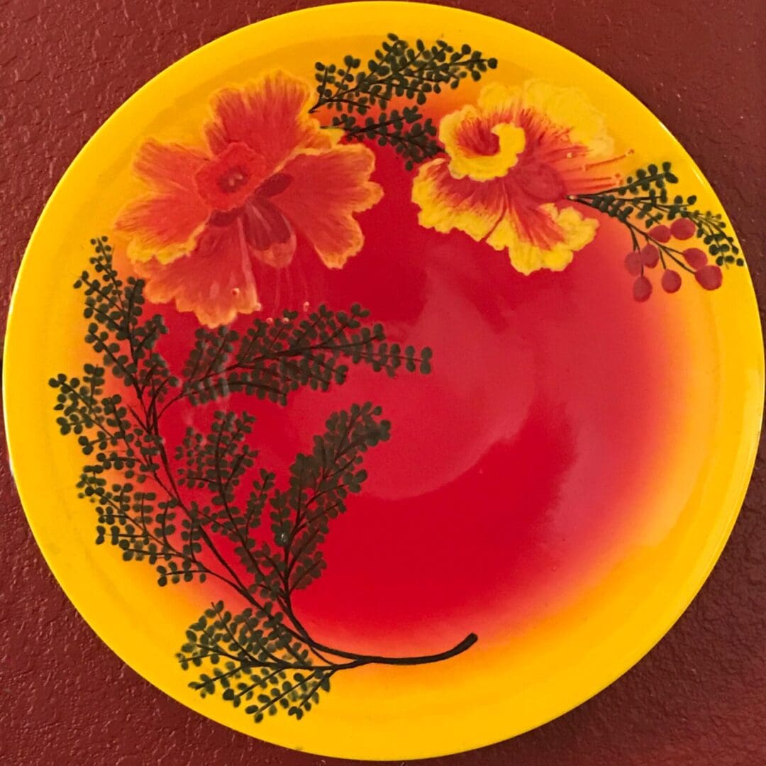 A yellow and red plate with flowers on it