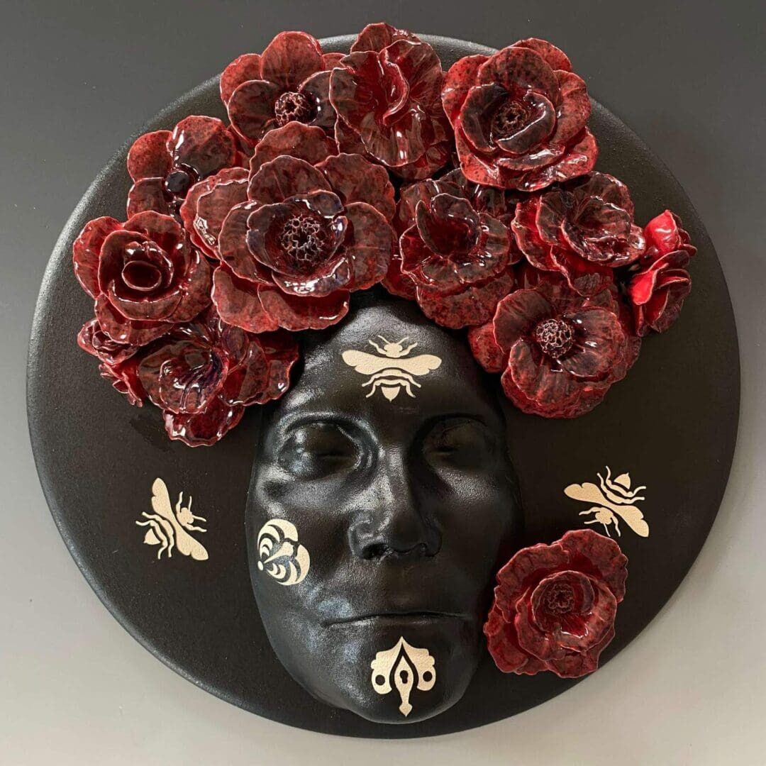 A black face with red flowers on it's head.