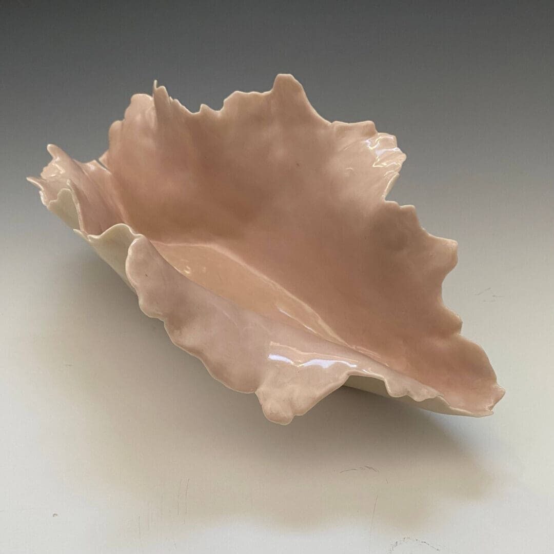 A bowl made of clay with a leaf design.