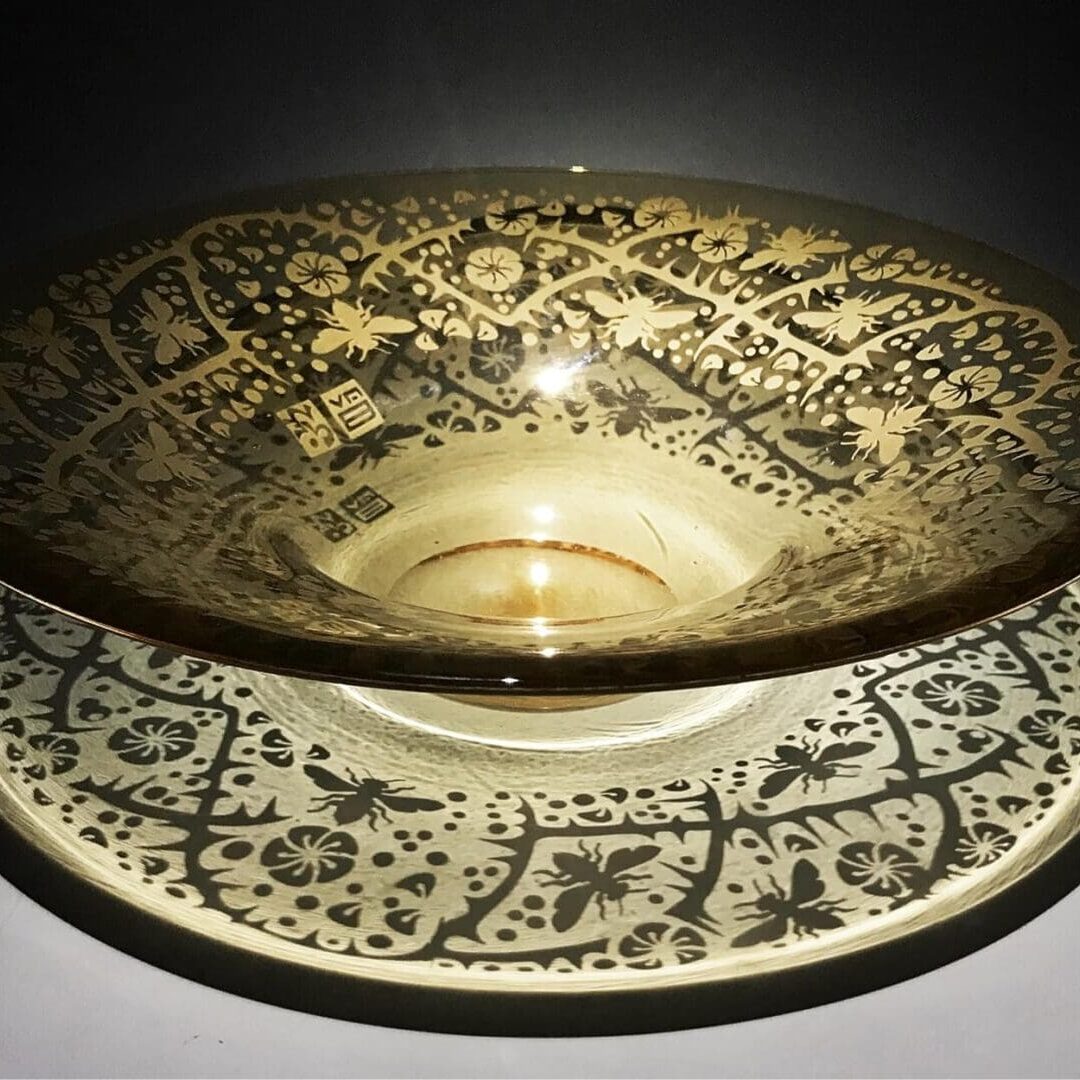 A bowl and plate with a black design on them.