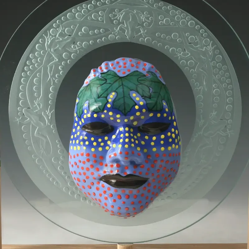 A glass sculpture of a woman 's face with colorful dots.